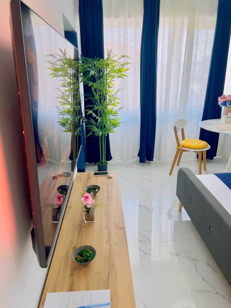 Una camera con un letto, un tavolo, una sedia, una pianta in vaso e una TV — monolocale a Pitesti