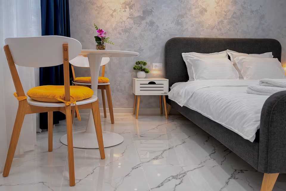 Una camera con un letto, un tavolo e una sedia — monolocale a Pitesti