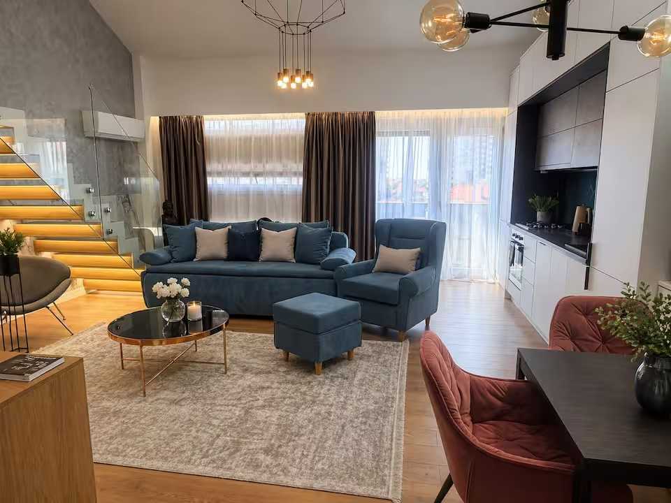 Un soggiorno con divano blu e sedia — appartamento a Oradea