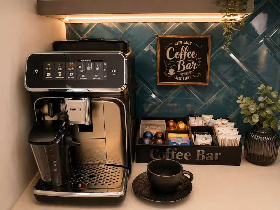 Una macchina da caffè nera e argentata su una panca — appartamento a Oradea