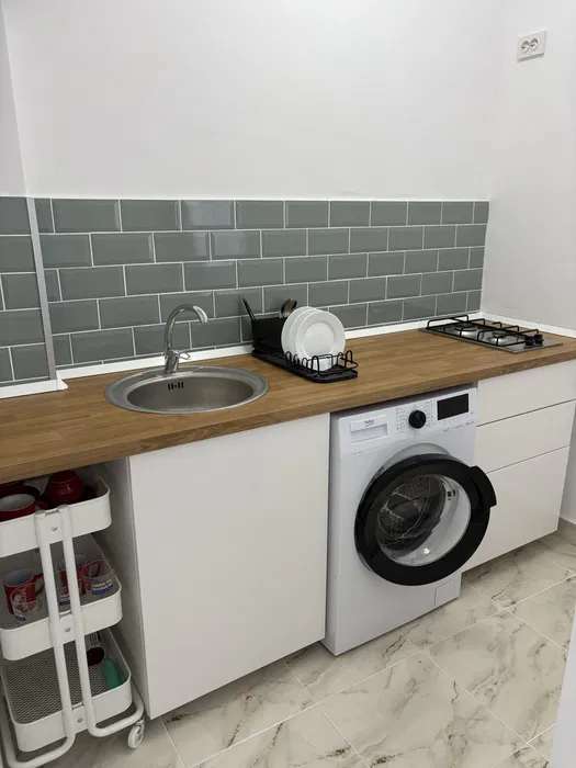 Una piccola cucina con una tazza, un asciugacapelli e una finestra