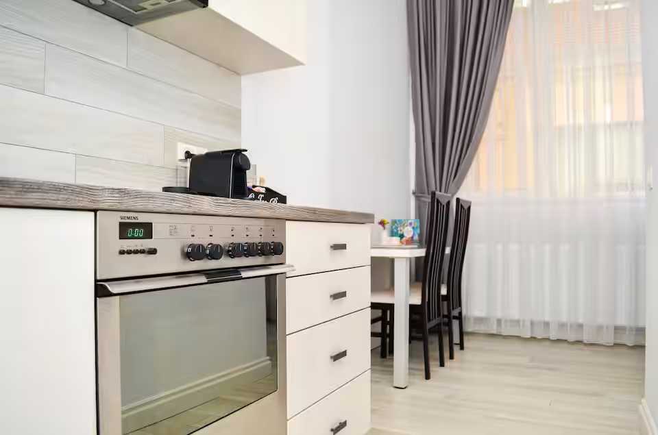 Una cucina con un forno e un tavolo — monolocale a Oradea