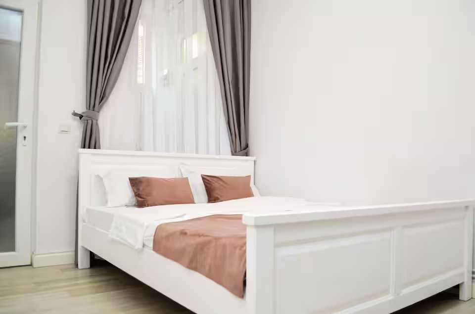 Una camera con letto bianco e finestra — monolocale a Oradea