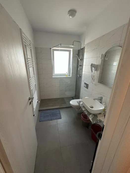Un piccolo bagno con un wc bianco e una finestra — monolocale a Brașov