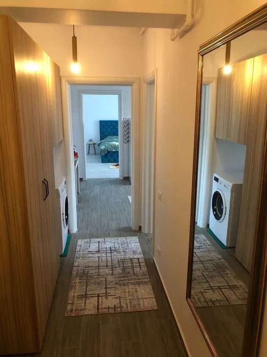 Una piccola stanza bianca con un letto e una lavasciuga — monolocale a Brașov