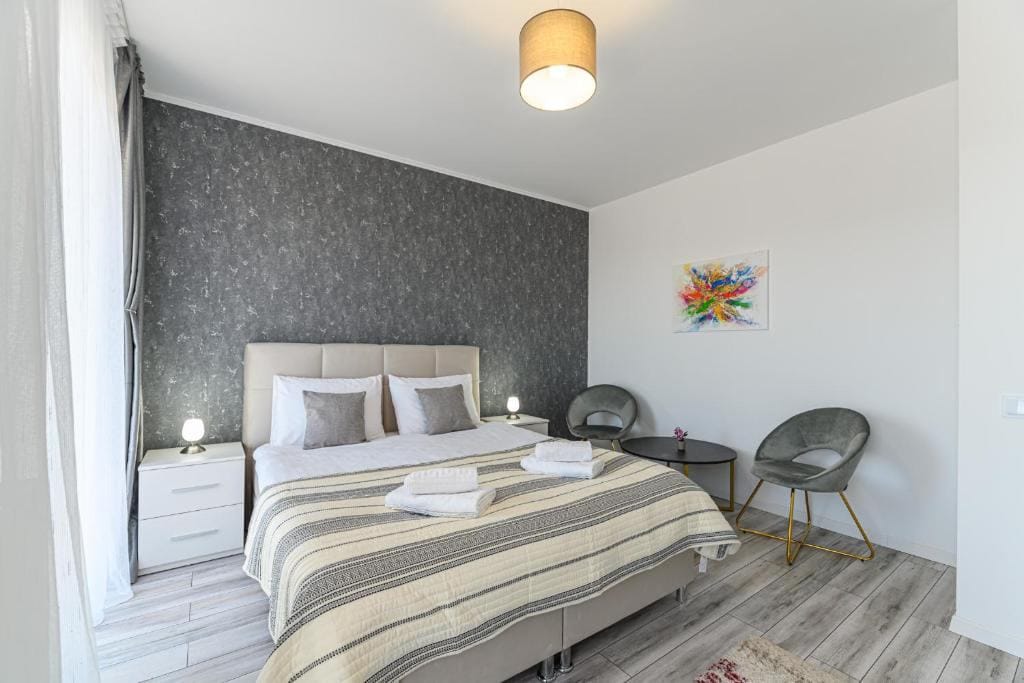 Una camera con letto, sedia e lampada — appartamento a Brașov