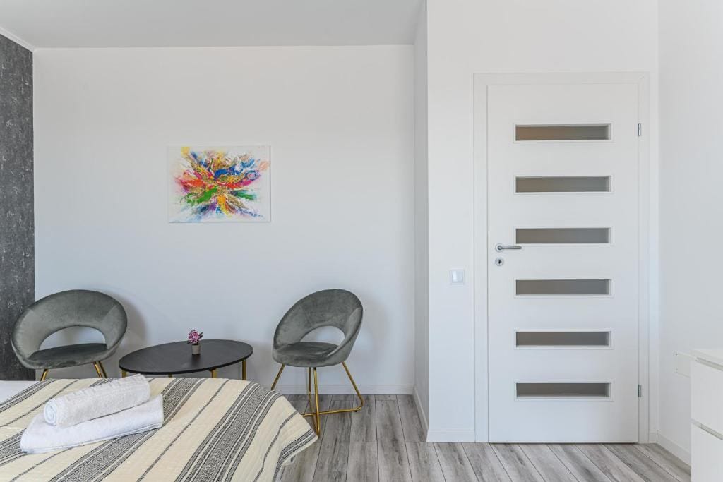 Una camera con letto, sedia e un dipinto sul muro — appartamento a Brașov