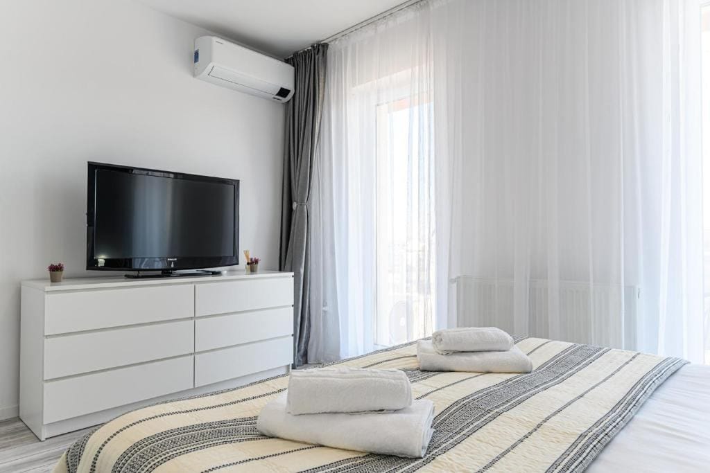 Una camera con letto, TV e finestra — appartamento a Brașov