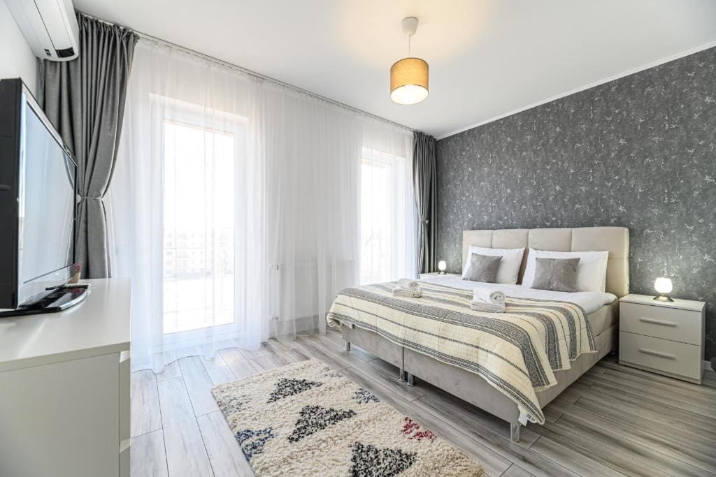 Una camera con un letto, una lampada e una finestra — appartamento a Brașov
