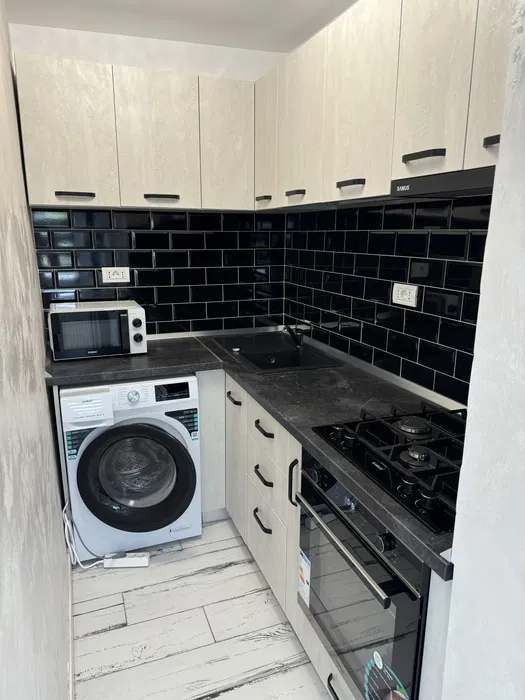 Una piccola cucina con forno top e asciugacapelli