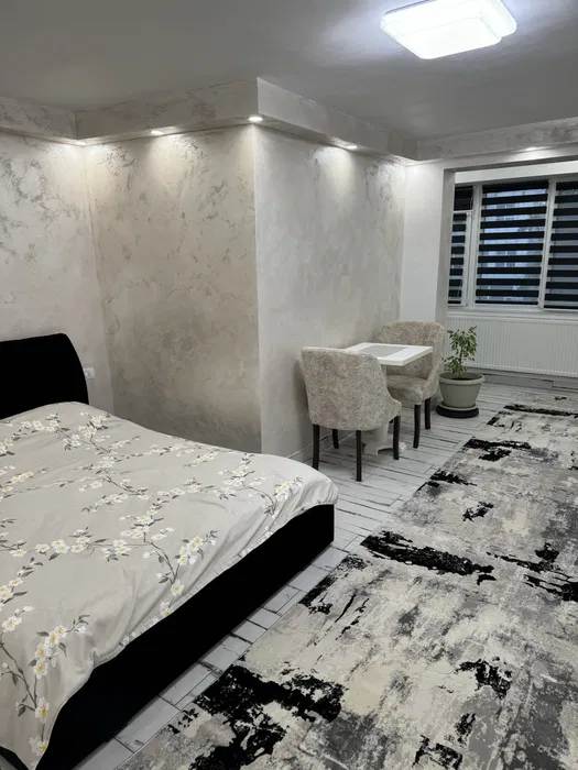 Una stanza con un letto, una sedia e una finestra
