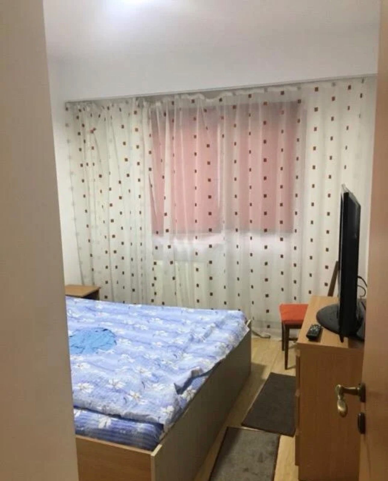 Una camera con un letto, una sedia e una TV