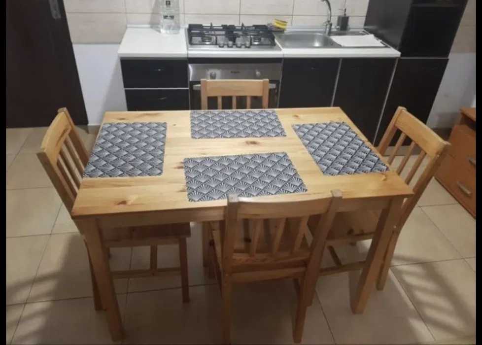 Una cucina con un tavolo in legno e sedie