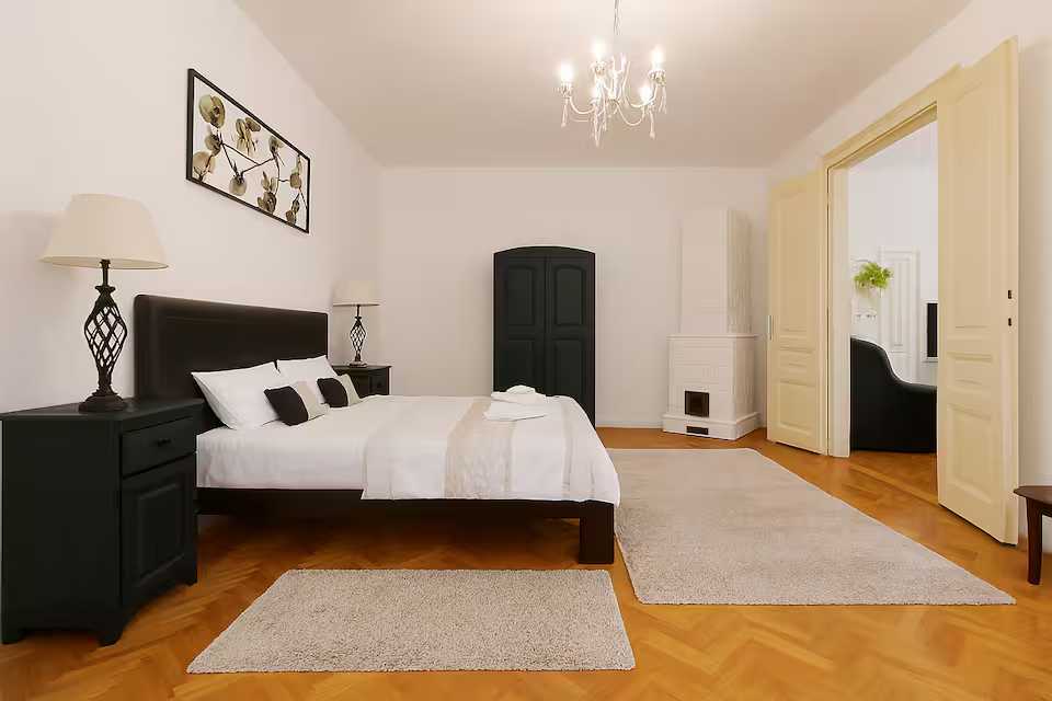 Una camera con un letto, un armadio e un lampadario — appartamento a Oradea