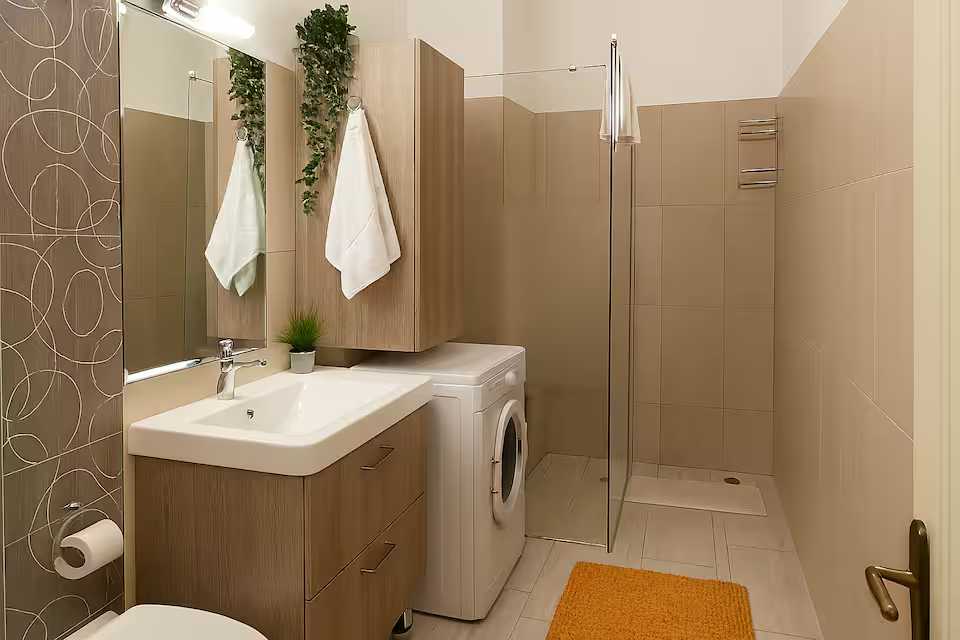 Un piccolo bagno con lavandino e una lavasciuga — appartamento a Oradea