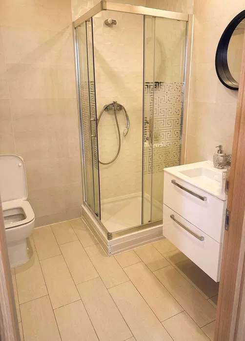 Un bagno con water, lavandino e doccia — appartamento a Bucuresti