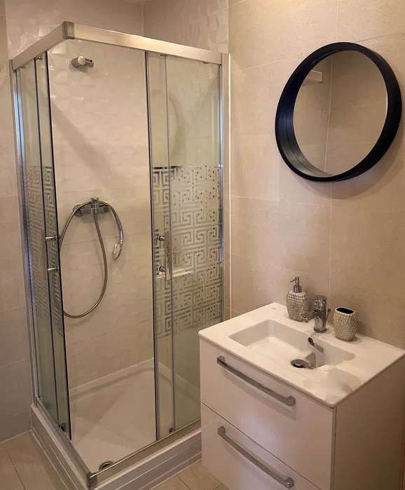 Un bagno con doccia e lavandino — appartamento a Bucuresti