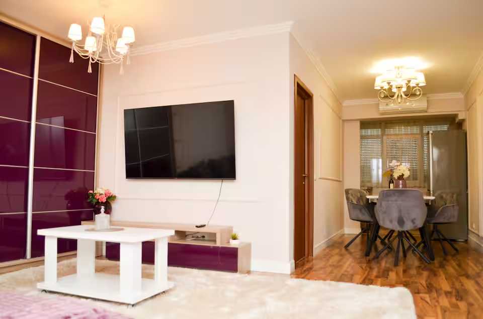 Un soggiorno con TV a schermo piatto e tavolo — appartamento a Oradea