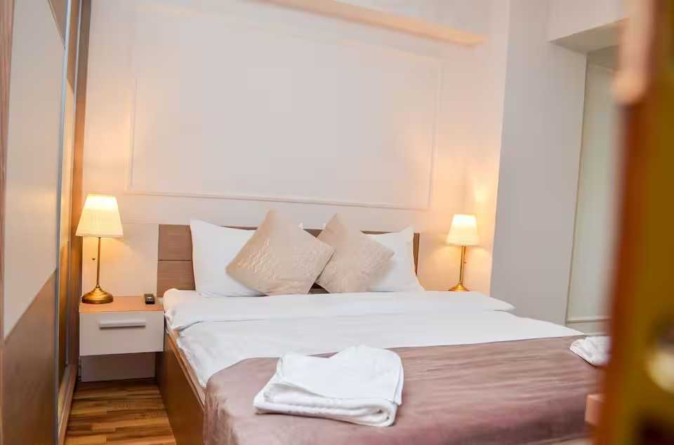 Una camera con un letto e una lampada — appartamento a Oradea