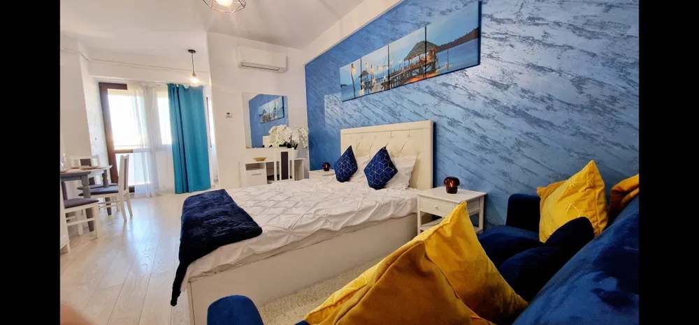 Una stanza con un letto, una sedia e un dipinto sulla parete
