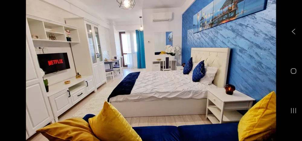 Una stanza con un letto, un tavolo, una sedia e una finestra